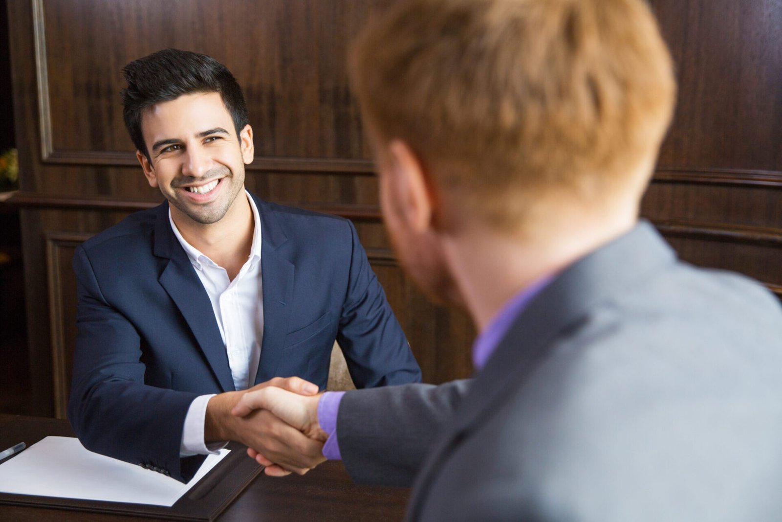IP professionals shaking hands to symbolize successful patent negotiation and strategic legal support for intellectual property."