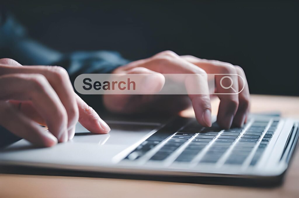 Article text about patent law above a photo of hands typing on a laptop with a search bar overlay.