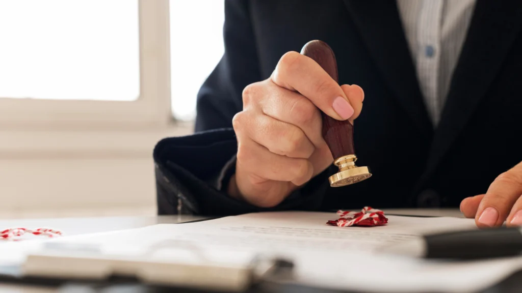 professional in a suit stamping an official legal document with a wax seal, representing the patent publication and opposition process under the Indian Patents Act.