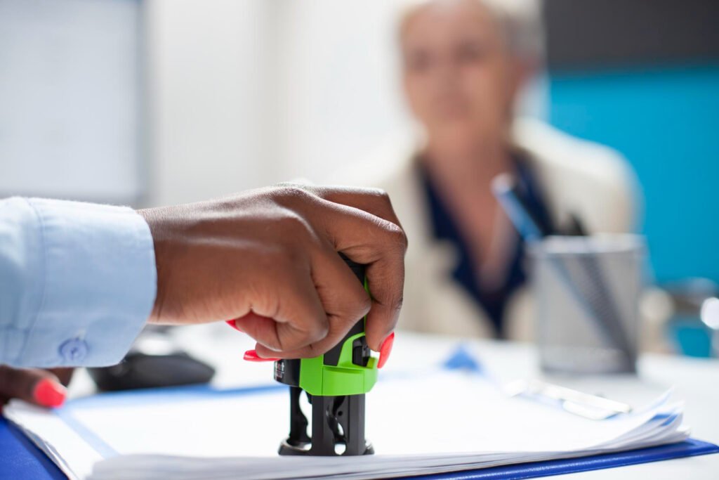 Person stamping a patent licensing agreement document in an office.