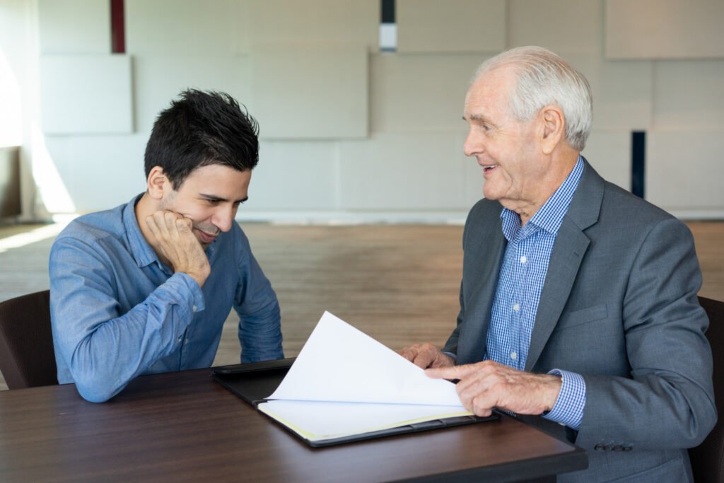 A patent applicant discussing prior art objections and inventive steps with an expert or patent controller over a document.