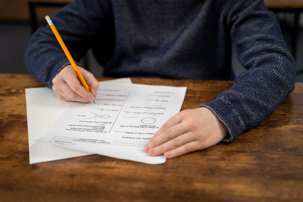 A person filling out an application form at a wooden desk.