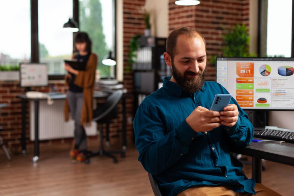 Man using a smartphone in an office discussing whether you can patent a business method app.