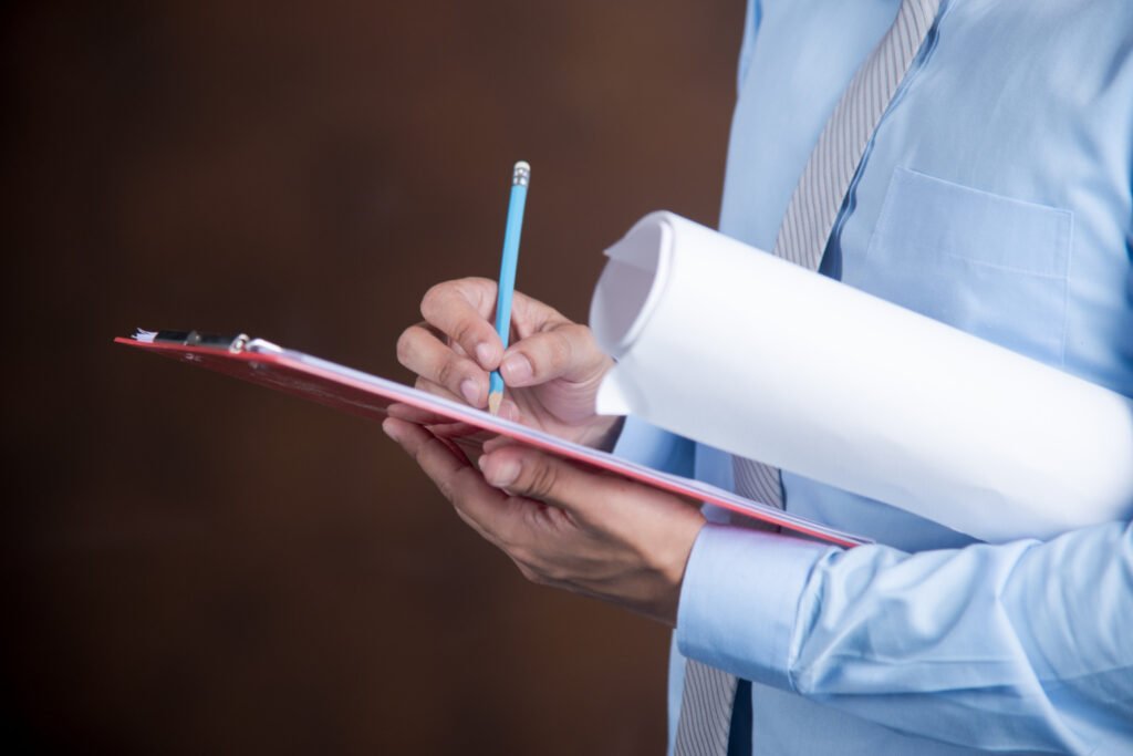 Professional writing on a clipboard with text explaining Section 10 provisions for patent specification requirements under Indian patent law.